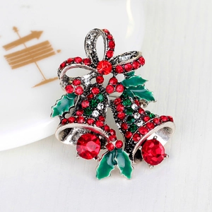 Close-up of festive Christmas bell brooch with red bow and colorful rhinestones