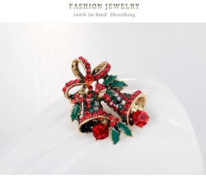 Macro view of Christmas double bell brooch with red rhinestones and green enamel leaves