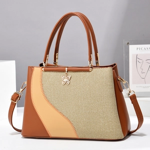 Stylish tricolor woven tote bag with a golden butterfly pendant and detachable shoulder strap