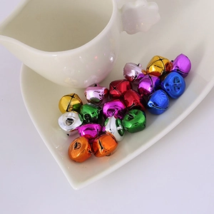 Colorful vacuum-plated metal pet bells displayed in a white heart-shaped plate decoration