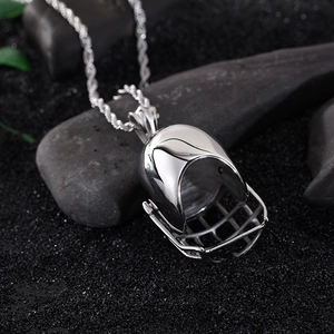 Polished silver stainless steel baseball helmet pendant necklace on dark textured stone