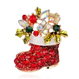 Christmas boot brooch with red rhinestones and gold base on white background