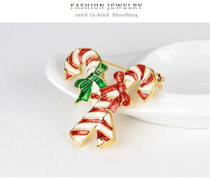 Macro detail of enamel candy cane brooch with festive red and green ribbons