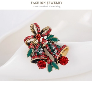 Detail of Christmas bell brooch with red and green rhinestones and golden bow