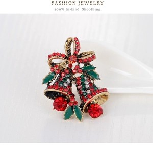 Detail of Christmas bell brooch with red and green rhinestones and enamel holly leaves