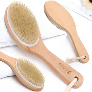 Detail of wooden bath brush with natural bristles and hanging rope on white towel