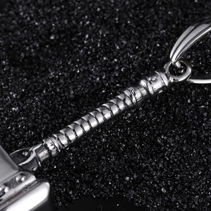 Polished silver Thor's hammer keychain on a textured black background