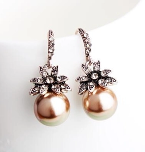 Detailed macro view of vintage sunflower earrings with champagne pearls and sparkling crystals