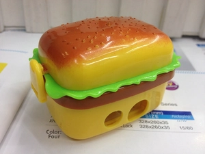 Close-up of burger shaped sharpener box with dual pencil holes and buckle closure
