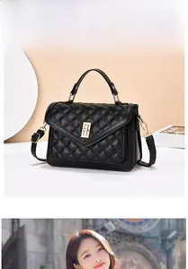 Détail d'un sac à main noir matelassé avec fermoir doré et bandoulière réglable