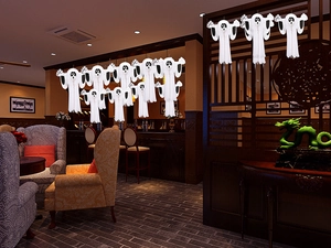 Hanging white 3D paper ghost decorations for Halloween party in a festive dining room