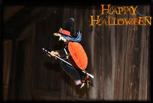 Detail of Halloween witch hanging decoration with orange honeycomb paper body and hat