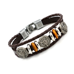 Detalle de pulsera de cuero trenzado marrón para hombre con dijes de calavera y hebilla