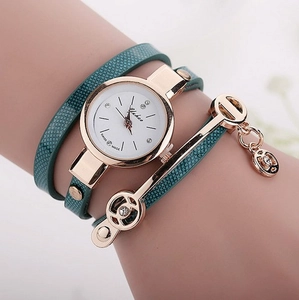 Detail of green snake-pattern wrap watch with rose gold case and geometric pendant