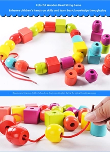 Close-up of colorful geometric wooden beads and a red threading string for kids' play