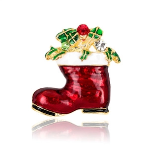 Macro detail of red Christmas boot brooch with holly leaves and sparkling crystals