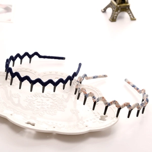 Detail view of navy blue and floral fabric-wrapped wavy headbands with inner teeth