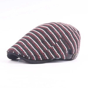 Detail of knitted newsboy cap featuring striped texture and adjustable leather buckle strap