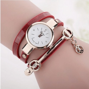 Detail of red leather wrap bracelet watch with gold angel pendant and rhinestone accents