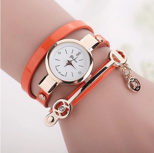 Detail of orange wrap-around quartz watch with rose gold charms and rhinestone accents