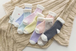 Detail of colorful coral fleece winter socks neatly arranged on a cozy knit blanket
