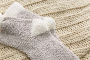 Detail of warm coral fleece winter socks in grey and white with soft fuzzy texture