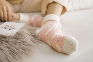 Detail of pink and white striped coral fleece socks with warm thick cuffs in a home setting