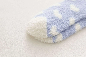 Close-up of seamless toe stitching on soft coral fleece socks with white polka dots