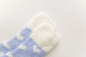 Close-up of heart pattern on thick coral fleece socks with blue and beige patchwork