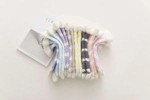 Close-up of thick coral fleece winter socks in various striped pastel color palettes