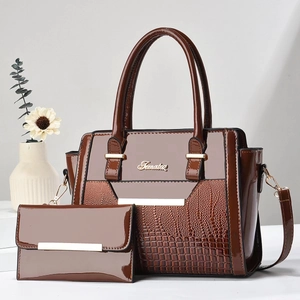 Detail of dark brown patent leather handbag and matching wallet with crocodile pattern