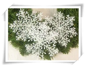 Close-up of white snowflake ornaments on a green Christmas wreath for tree decoration