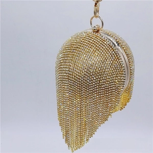 Detail of spherical evening bag featuring golden rhinestones and luxury diamond tassels