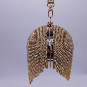 Detail of a spherical gold evening clutch featuring shimmering rhinestones and tassels