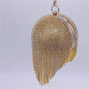 Detailed close-up of gold evening bag with rhinestones and sparkling fringe tassels