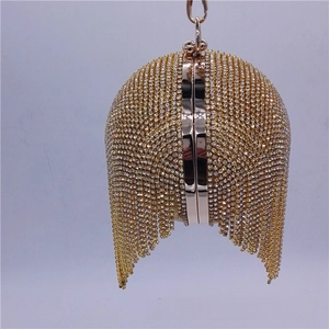 Detail of spherical evening clutch featuring gold and silver rhinestones and metal tassels
