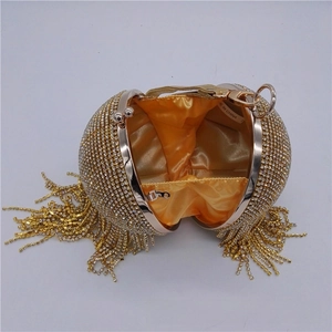Detailed interior of a spherical crystal evening bag with gold satin lining and tassels