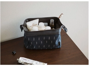 Detail of dark grey fabric organizer with tree print holding toiletries on wooden desk