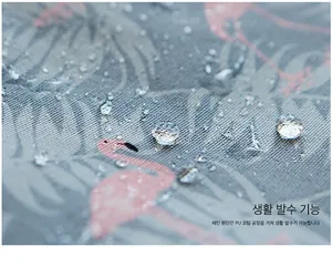 Detailed macro view showing the waterproof PU coating with flamingo patterns and water droplets