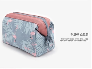 Detail of flamingo cosmetic bag showing reinforced webbing handle and pink zipper closure