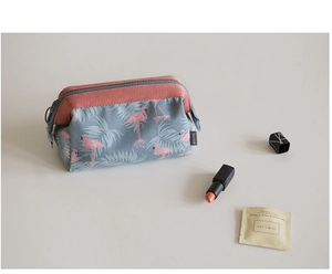 Detail of pink flamingo pattern fabric on a blue travel cosmetic bag with zipper