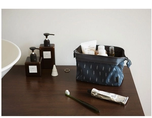 Blue flamingo storage bag with leaf pattern shown open with cosmetics on vanity