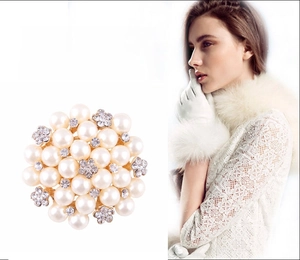 Detailed cluster brooch featuring cream pearls and sparkling rhinestone floral accents