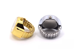 Detail of silver and gold finger ring watches with flexible stretch bands and glitter dials