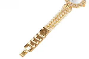 Close-up of luxury women's watch featuring a three-row pearl band and crystal bezel