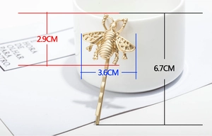 Macro view of matte gold bee hair clip showing 6.7cm length and 3.6cm width detail