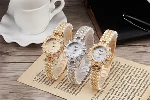 Close-up of luxury women's quartz watches with pearl bands and sparkling rhinestone bezels