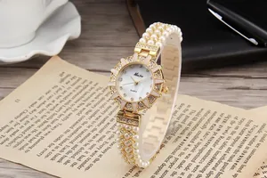 Detailed macro of gold sunflower quartz watch with crystal inlay and pearl strap