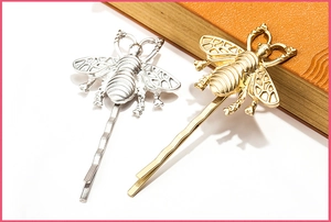 Detailed close-up of matte gold and silver honeybee hair clips with hollow wings