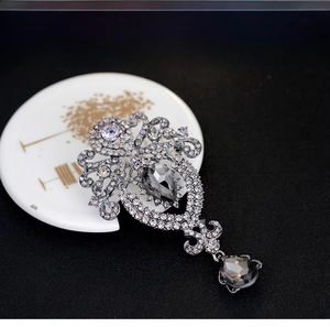 Macro view of vintage silver crown brooch with smoky grey pear-cut crystals and rhinestones
